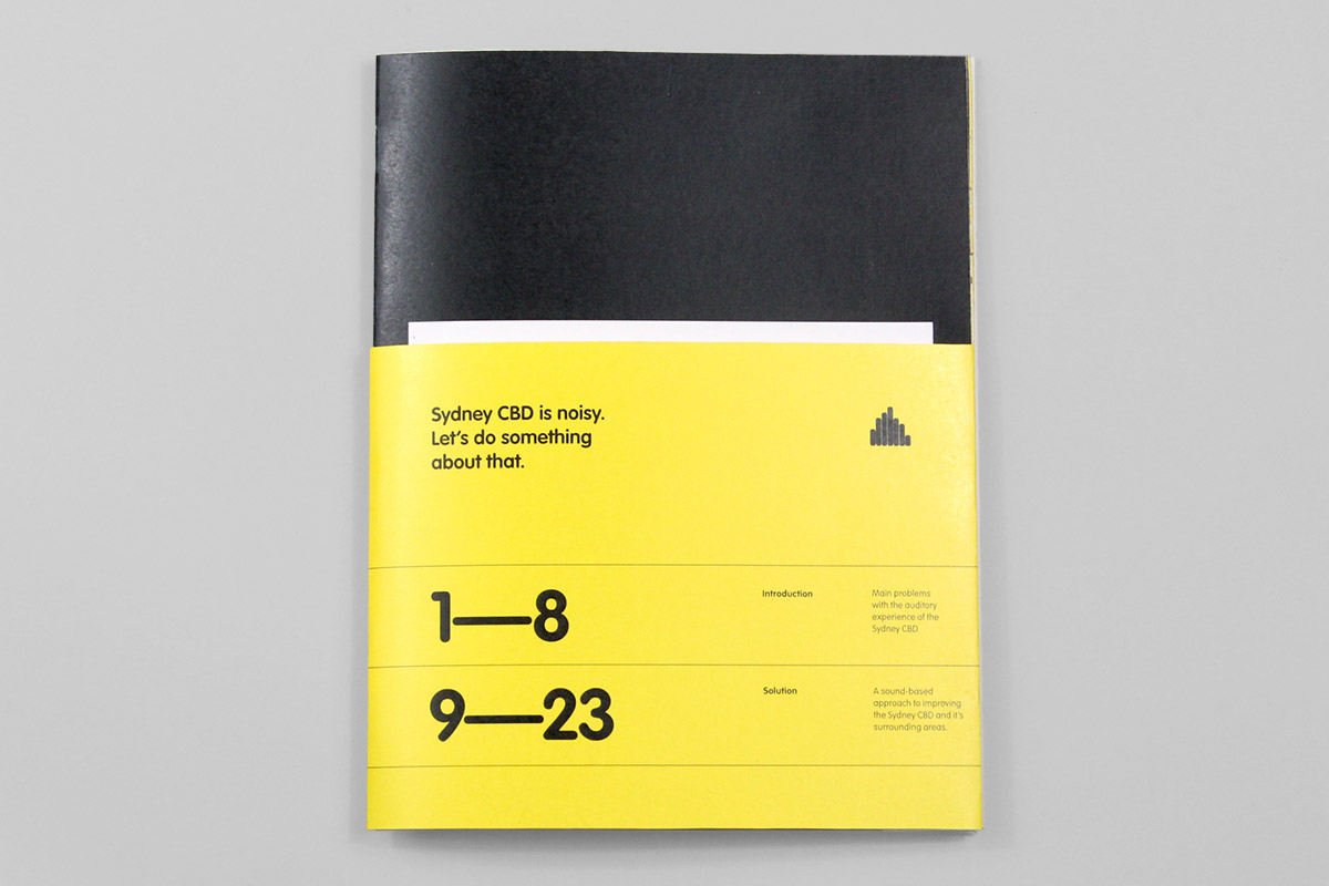 Booklet with a black cover partially wrapped in a yellow band. The text on the yellow band reads 'Sydney CBD is noisy. Let’s do something about that.'.
